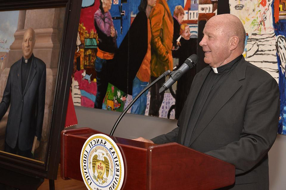神父比昂迪站在讲台上为他的肖像揭幕