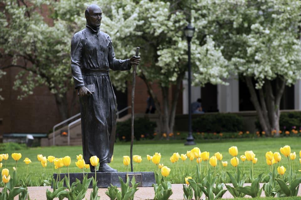 Ignatius statue in the quad surrounded by tulips