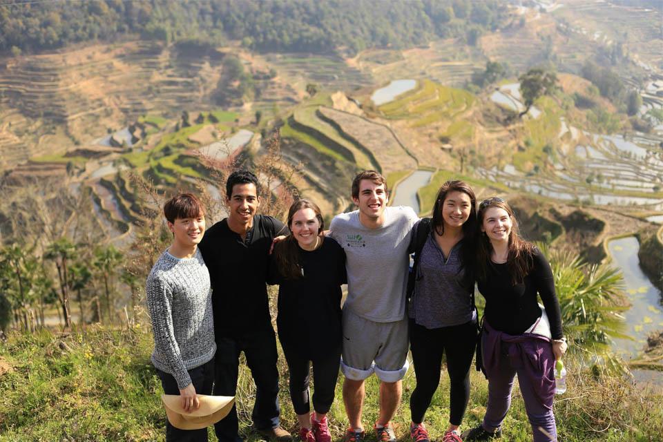 学生们站在山坡上，俯瞰着有梯田的山谷.