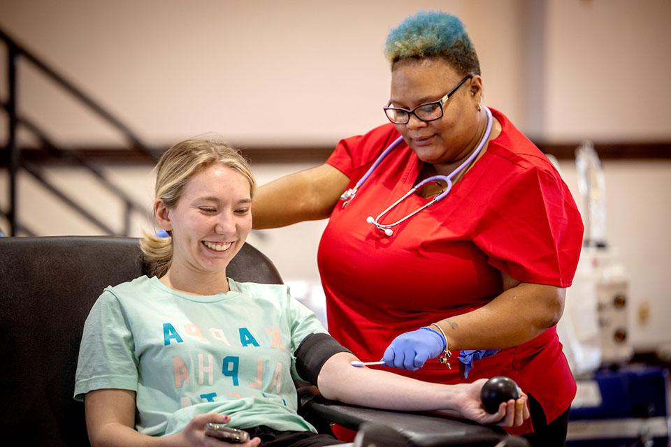 A student squeezes a stress ball while preparing to have her blood drawn during a blood drive hosted by the Center for Social Action.