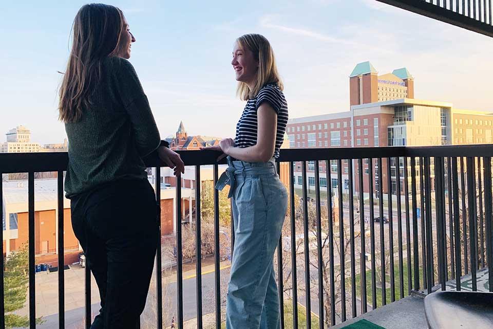 两个女学生站在阳台上俯瞰校园