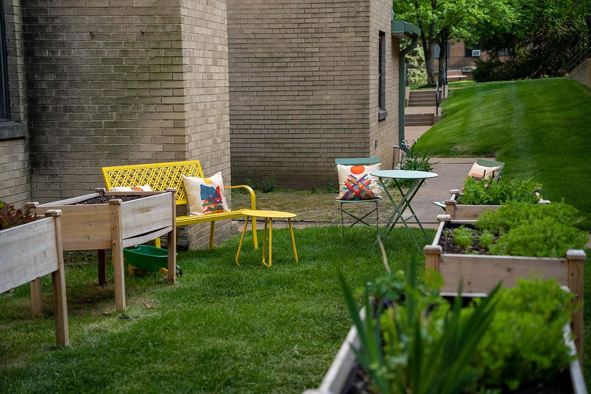 色彩鲜艳的椅子坐在建筑物外的草坪上，附近有景观箱.