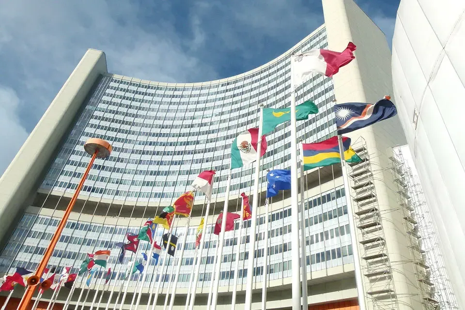 一排排的国际旗帜飘扬在一座高大的办公楼前.