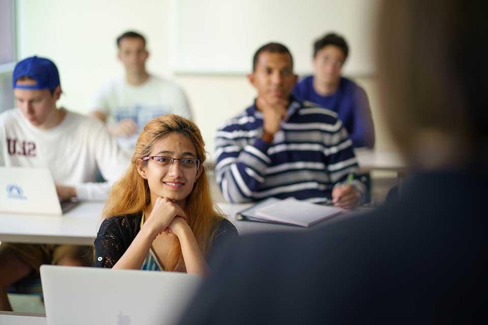 A classroom of students listens attentively to a lecture