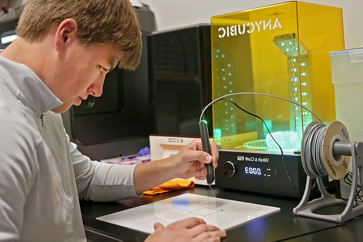 学生在工程实验室使用3D打印机